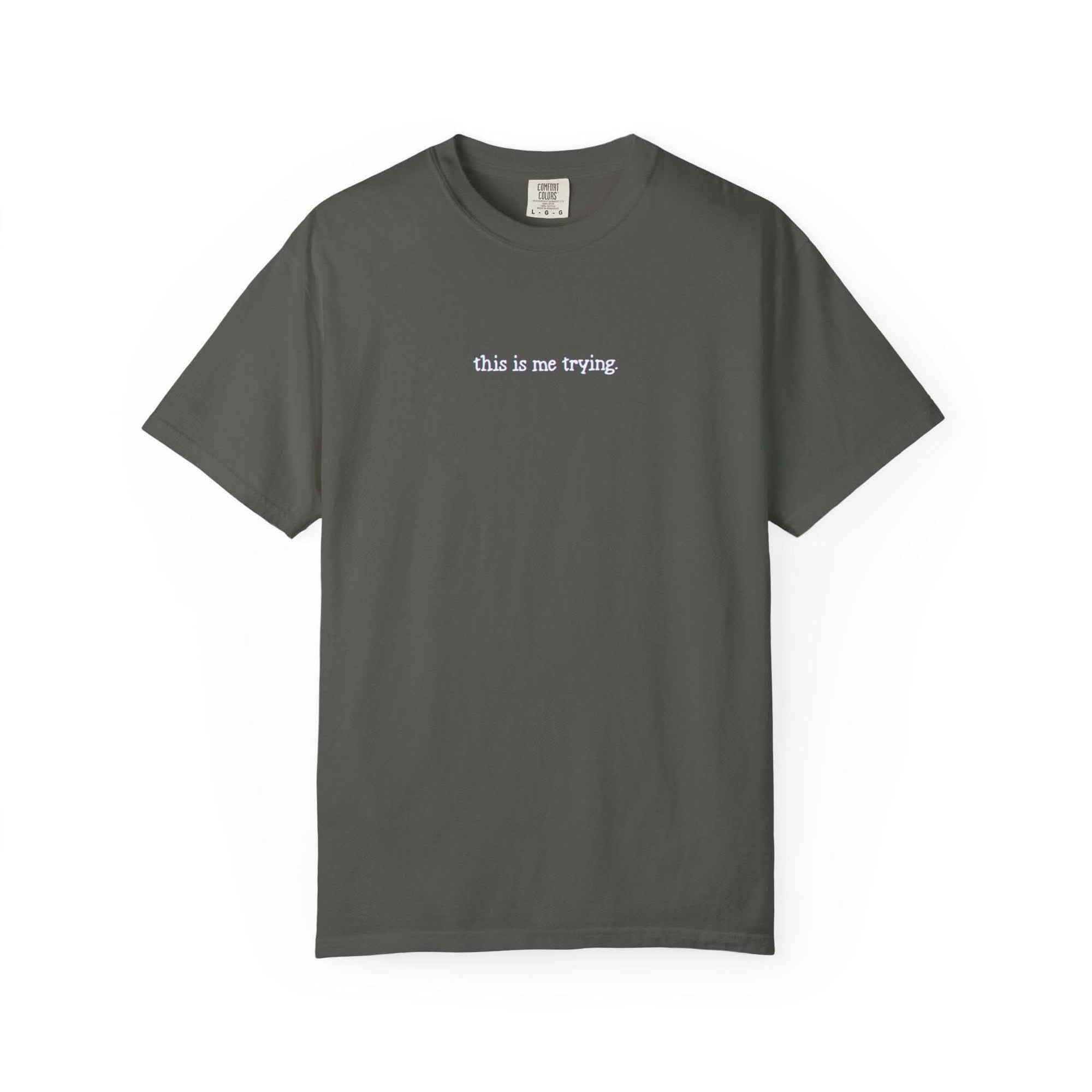 Gray t-shirt with 'this is me trying' text on a white background