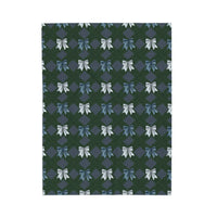 Velveteen plush blanket with winter coquette bows pattern in blue and white on dark green background