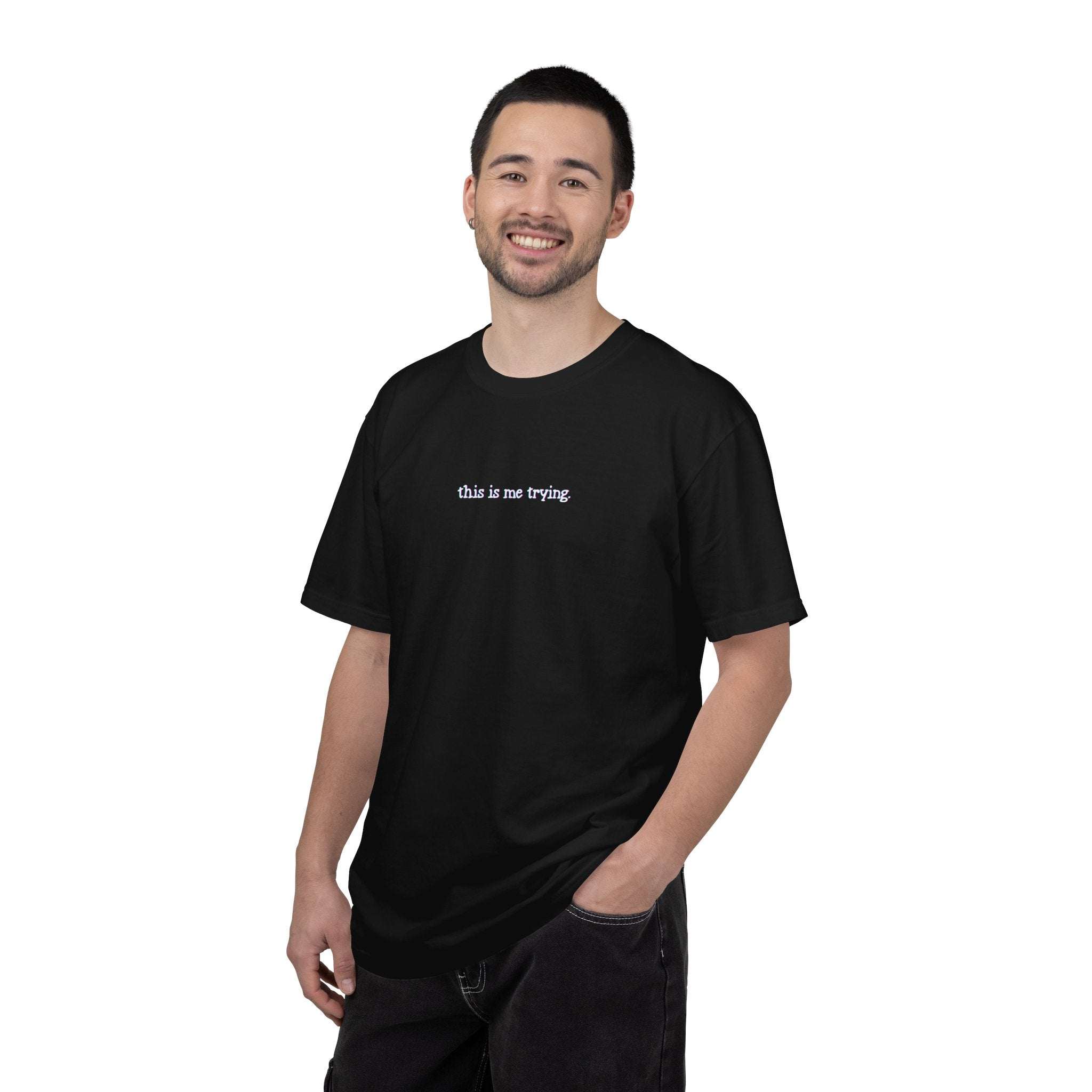 Man wearing a black t-shirt with 'this is me trying' text on a white background
