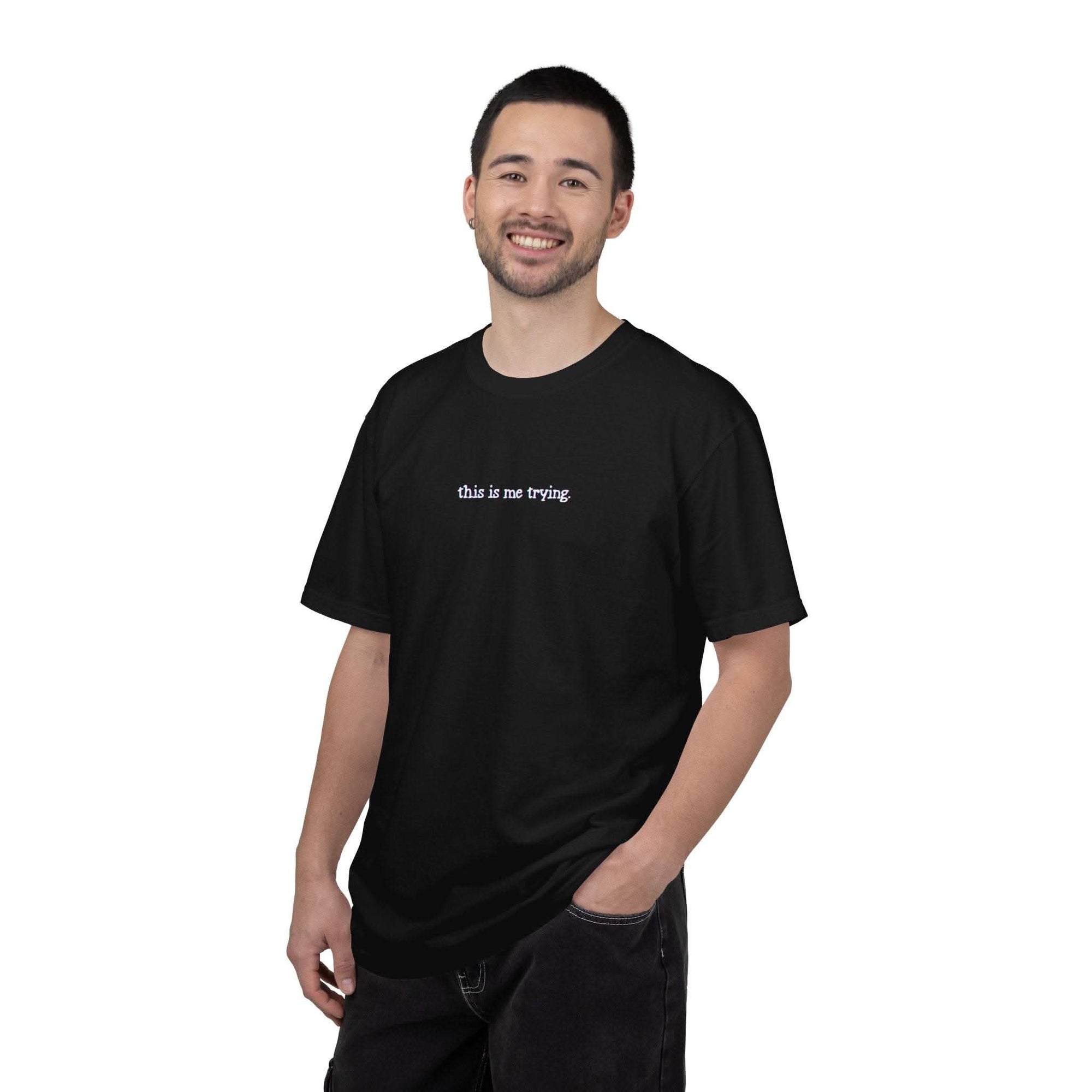 Man wearing a black t-shirt with 'this is me trying' text on a white background
