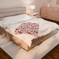 Soft velvety blanket featuring a vibrant floral axolotl surrounded by blossoms and hearts