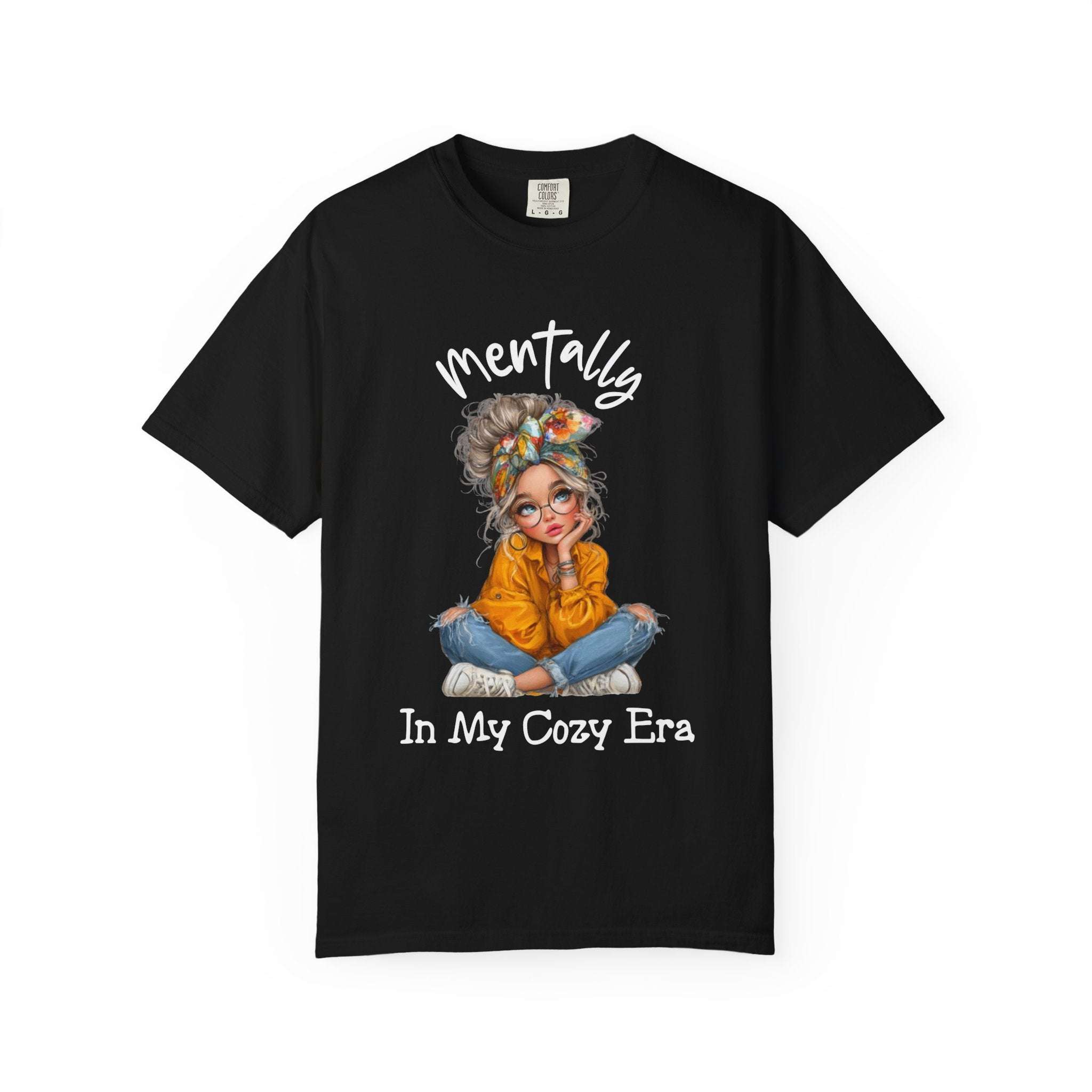 Black t-shirt with a graphic of a woman in an orange sweater and text 'mentally In My Cozy Era' on a white background