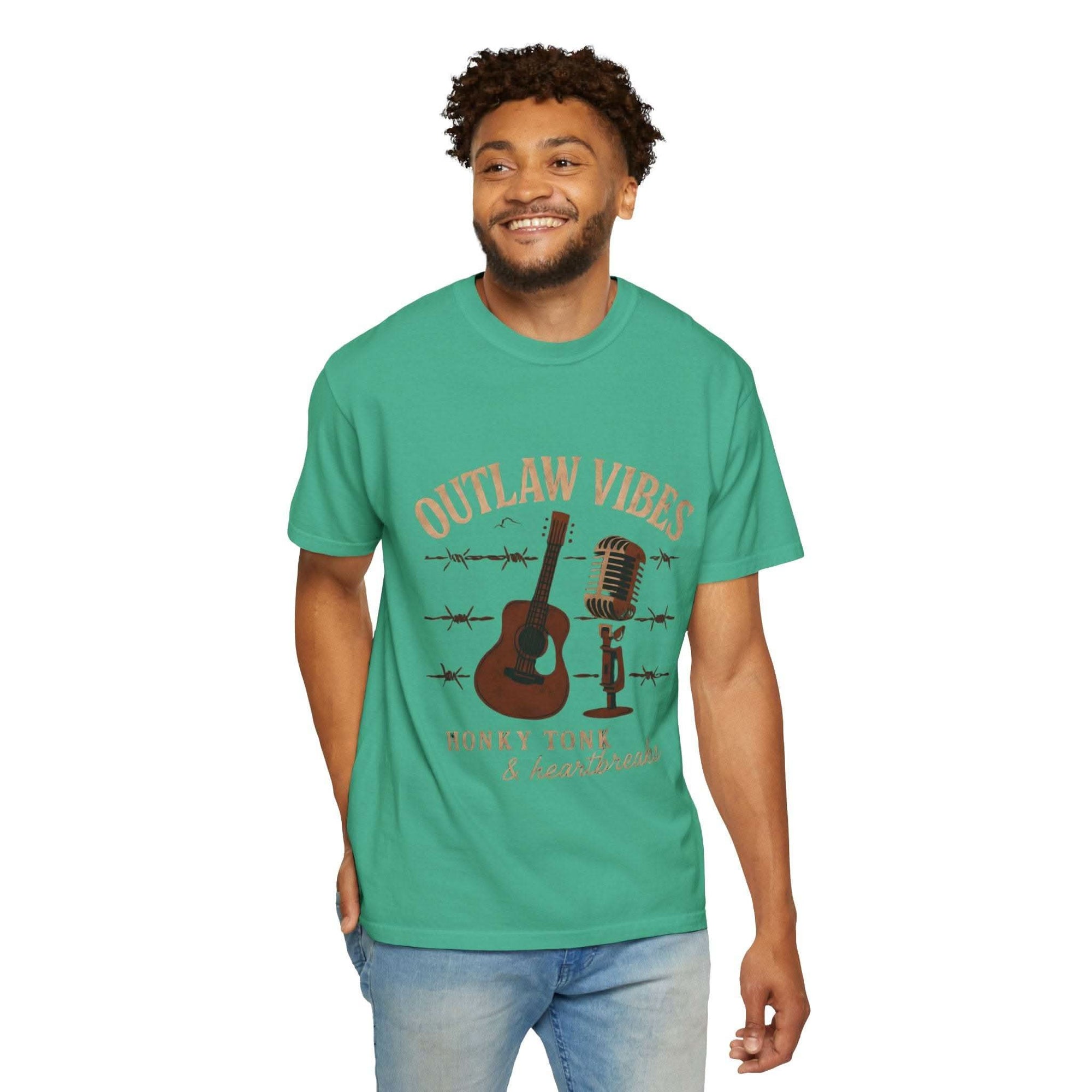 Man wearing a green t-shirt with 'Outlaw Vibes' graphic design on a white background