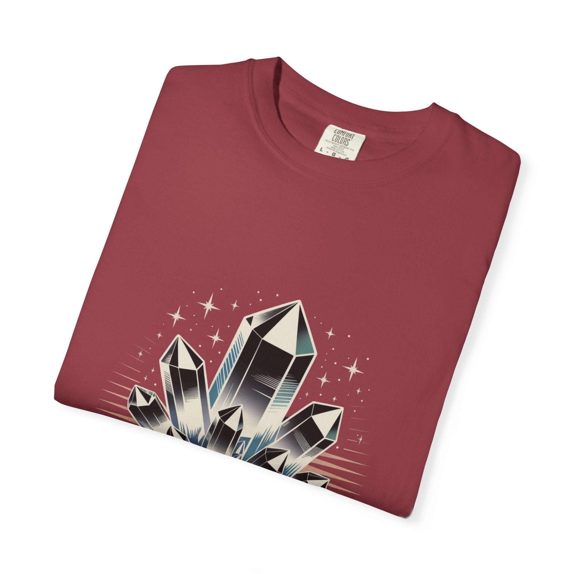 Folded maroon t-shirt with crystal graphic on a white background