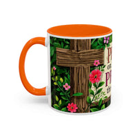 Mug with floral design and wooden cross on a white background