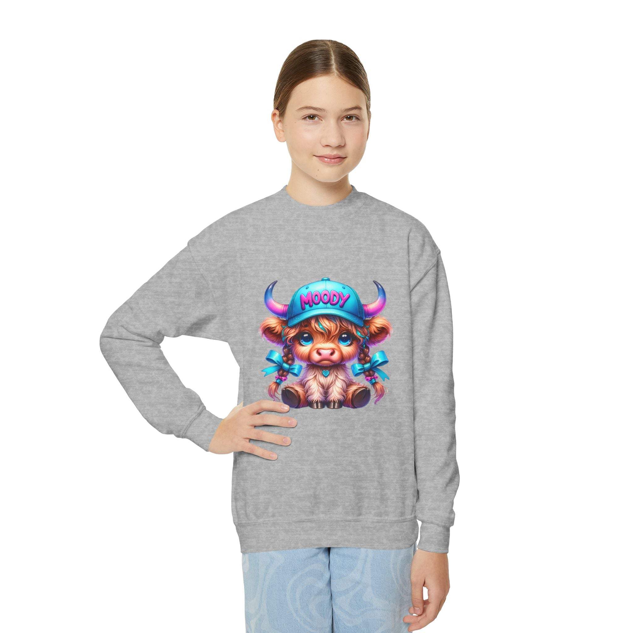Child wearing gray Moody Girl Highland Cow sweatshirt with colorful cartoon cow design on front