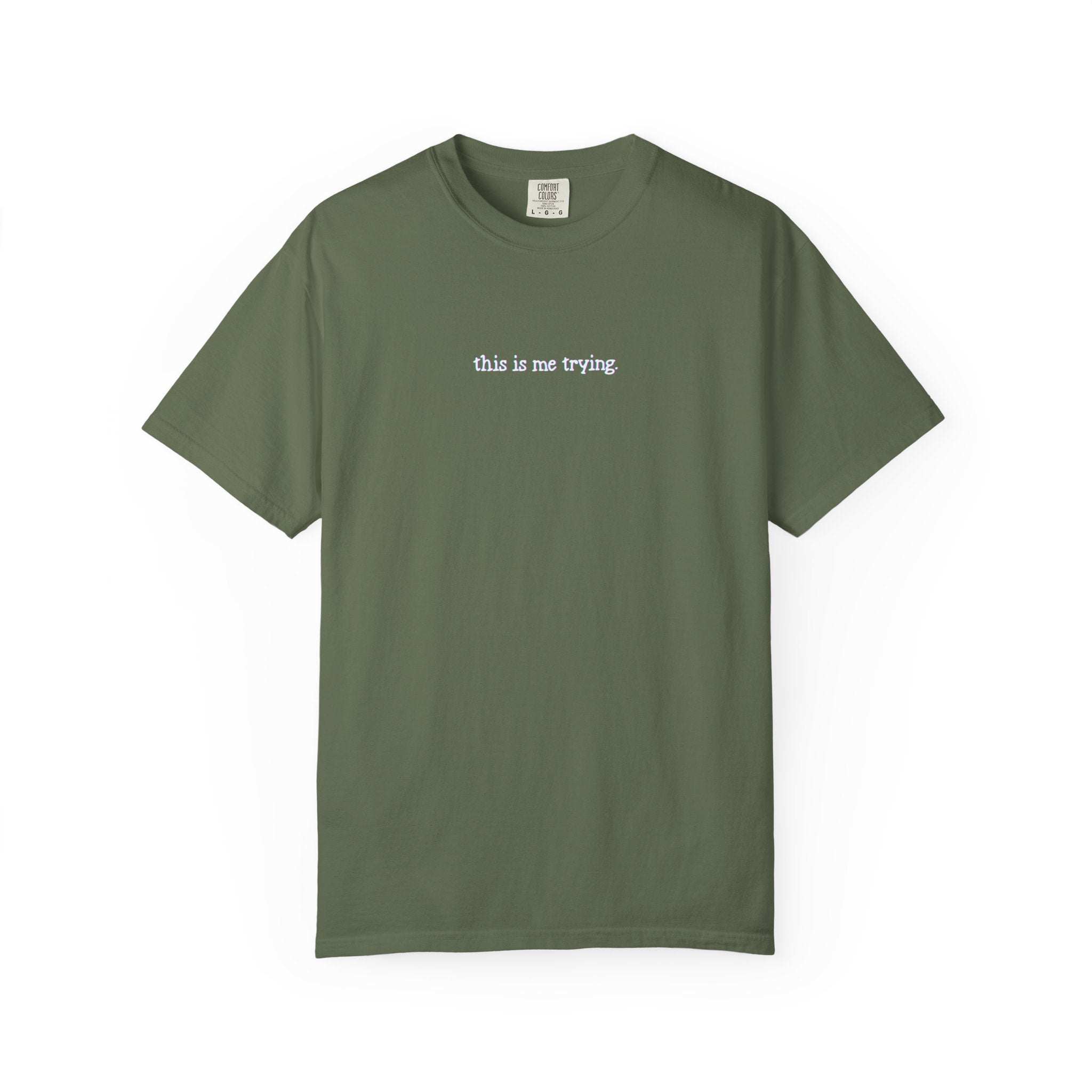 Green t-shirt with 'this is me trying' text on a white background