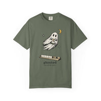 Flat lay of a moss green mahjong T-shirt with a ghost holding a joker tile above a tile rack and “ghosted (he took the joker)” lettering.
