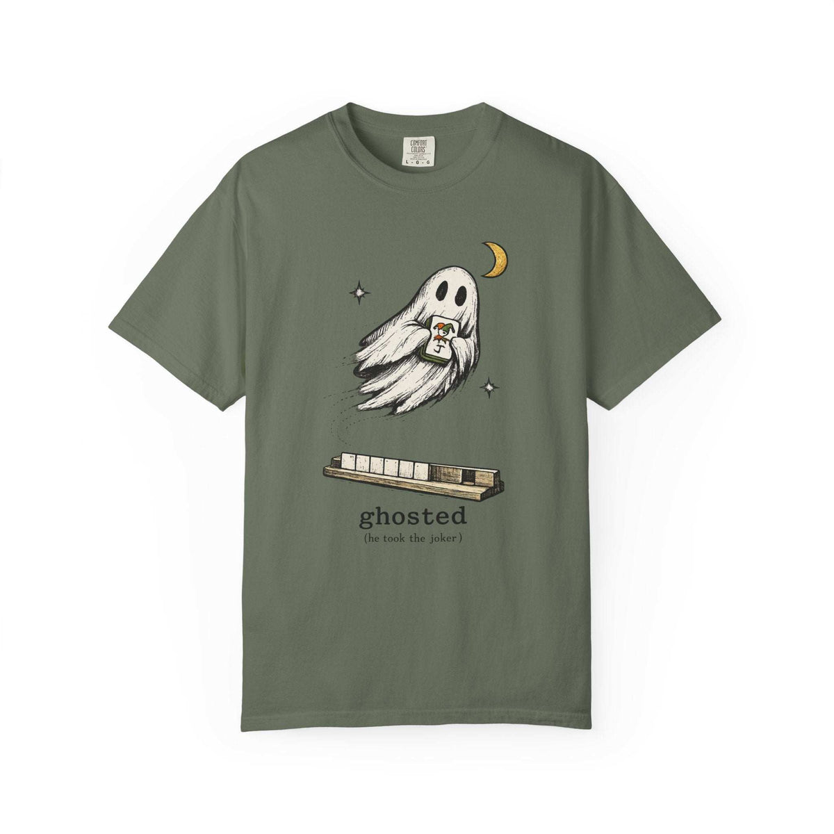 Flat lay of a moss green mahjong T-shirt with a ghost holding a joker tile above a tile rack and “ghosted (he took the joker)” lettering.