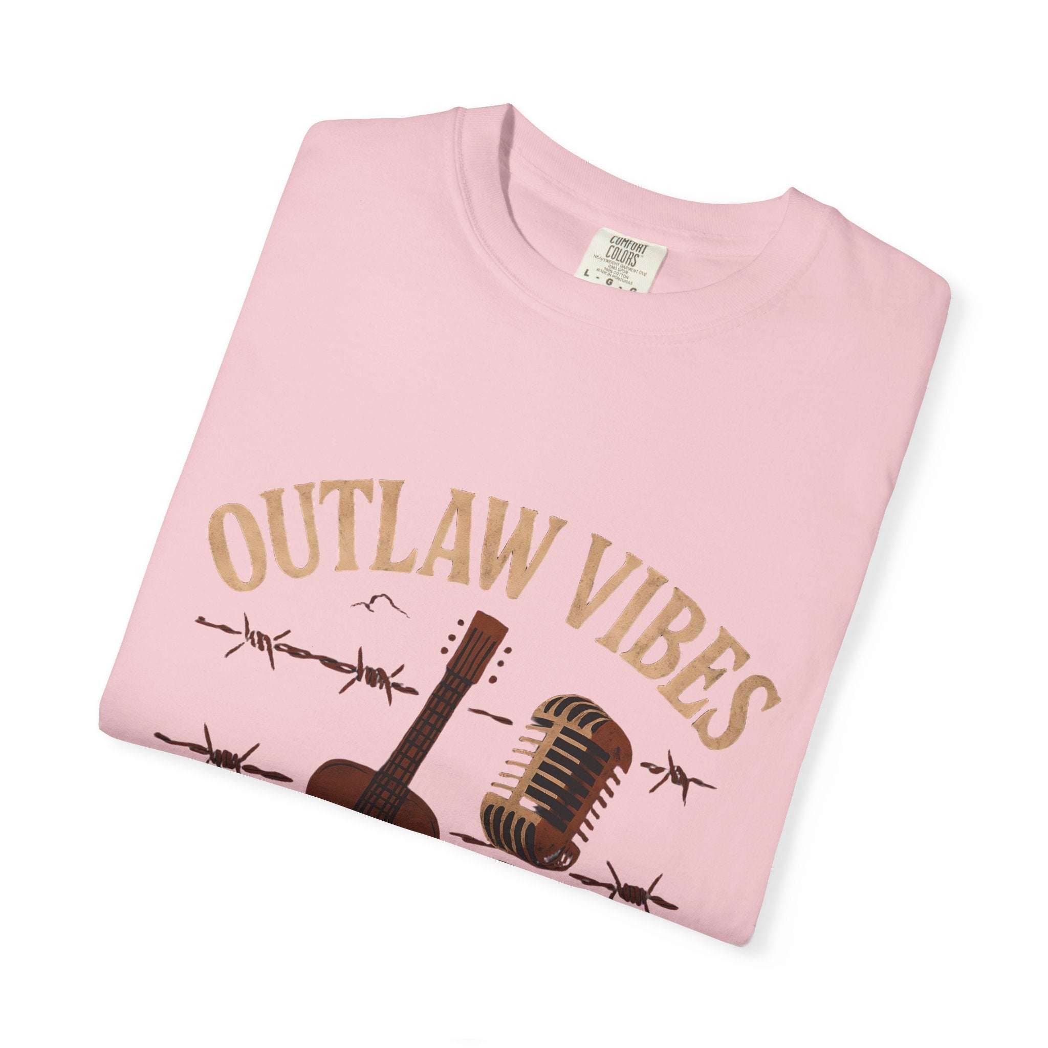 Pink t-shirt with 'Outlaw Vibes' text and guitar graphic on a white background