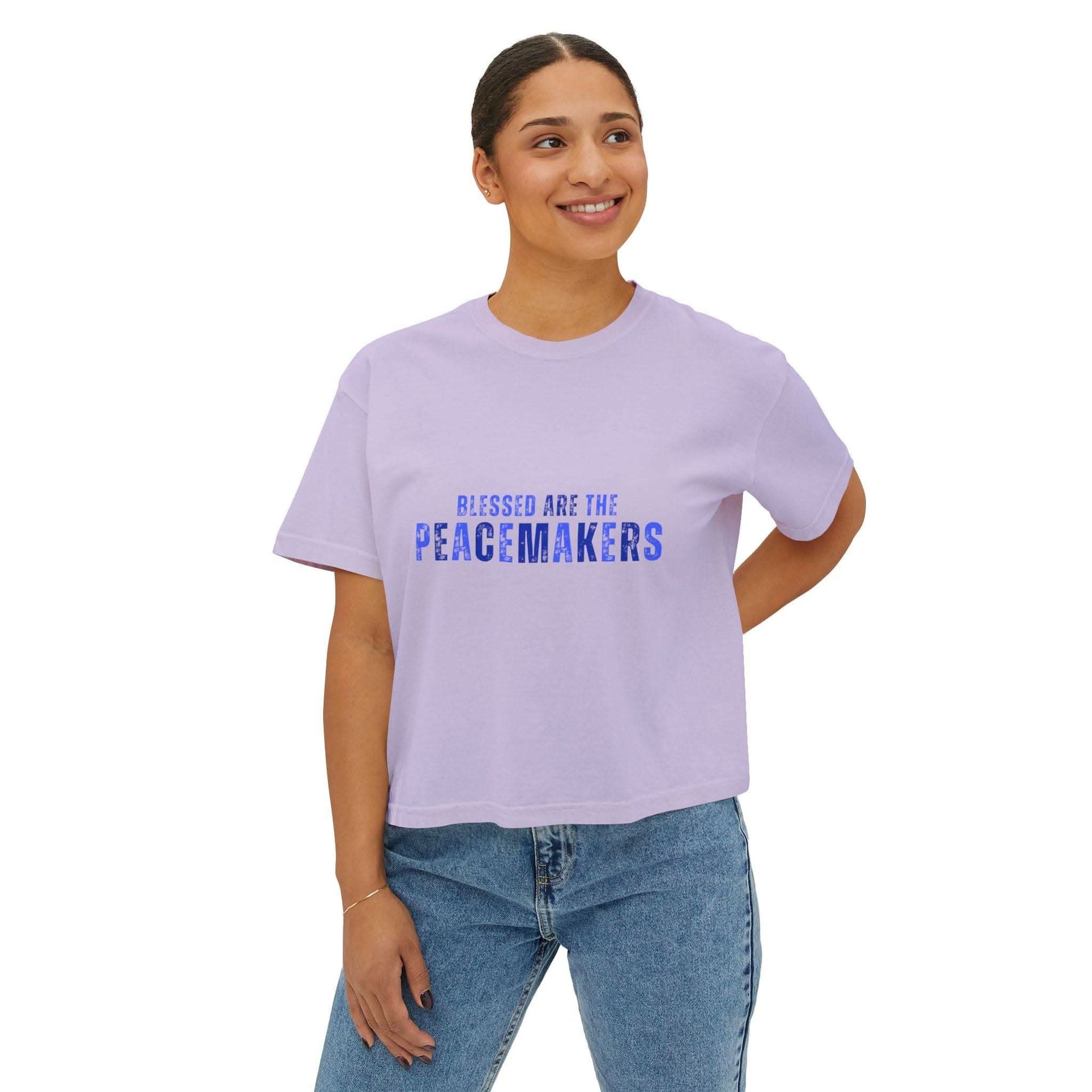 Women wearing lavender Tee Blessed be the Peacemakers boxy shirt with blue text, paired with jeans