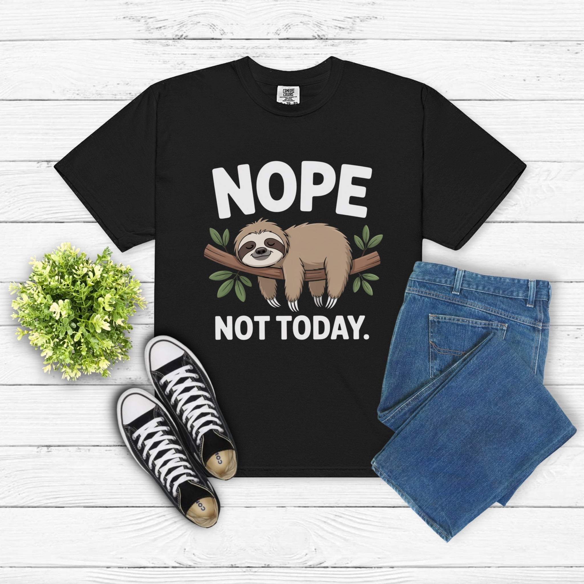 Nope Not Today Sloth black t-shirt with sloth graphic and text, paired with blue jeans and black sneakers on white wooden background