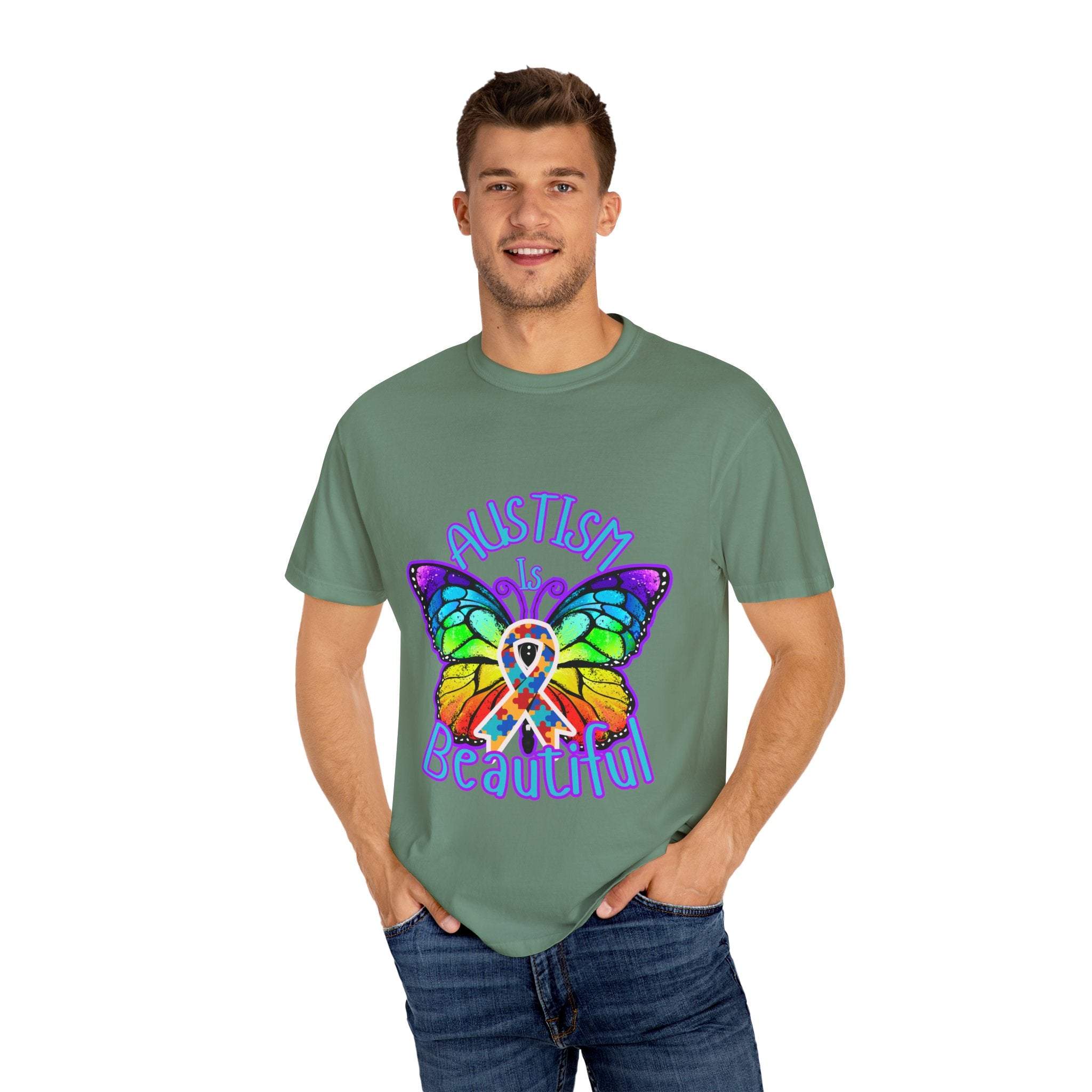 Man wearing green unisex Autism is Beautiful T-shirt with colorful butterfly design and autism awareness ribbon