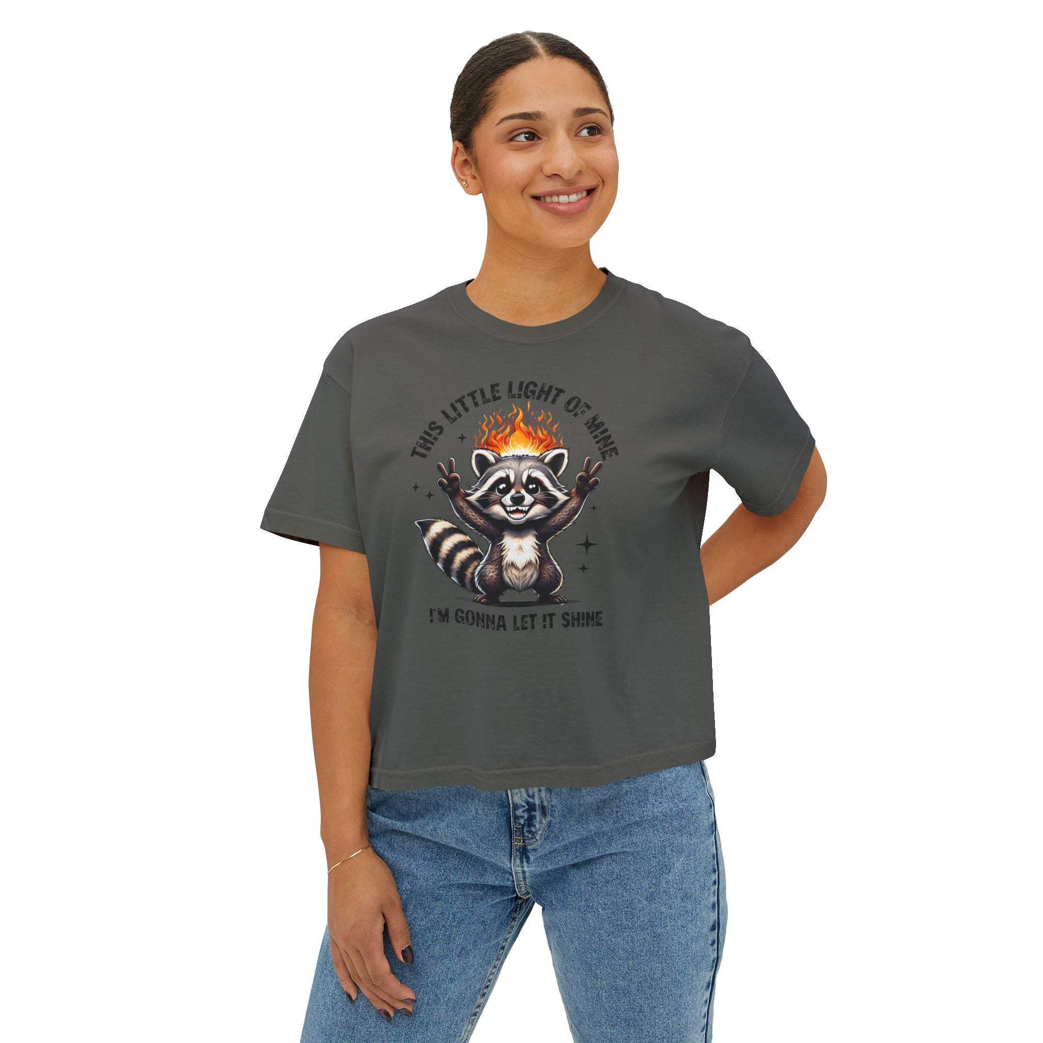 Person wearing a dark gray t-shirt with a graphic design of a raccoon and text on a white background
