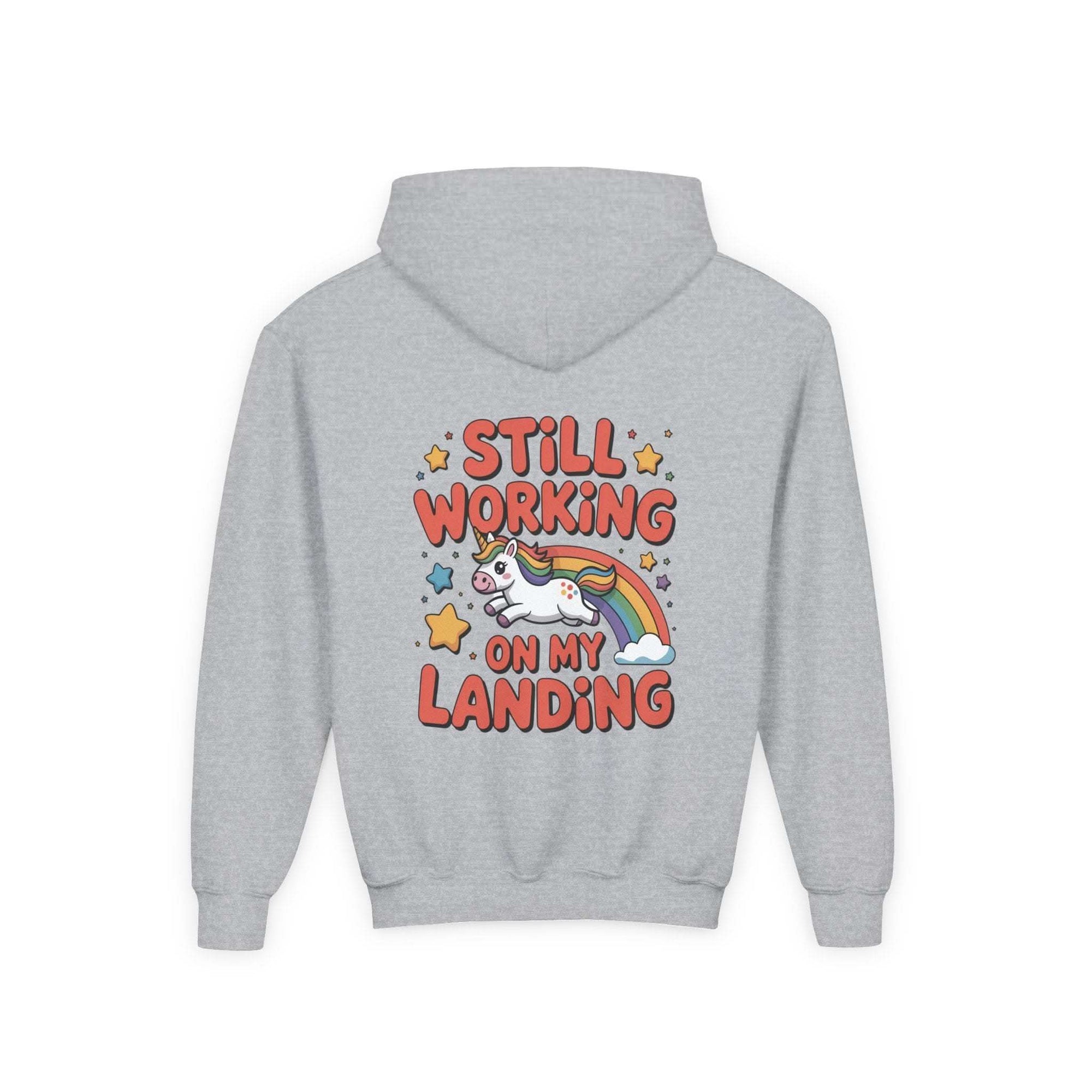 Kids hoodie with colorful cartoon unicorn and rainbow design, playful "Still Working On My Landing" text