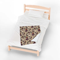 Cowboy Christmas plush blanket with festive western pattern on a wooden bed