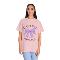 Person wearing a pink t-shirt with a purple bow and text on a white background