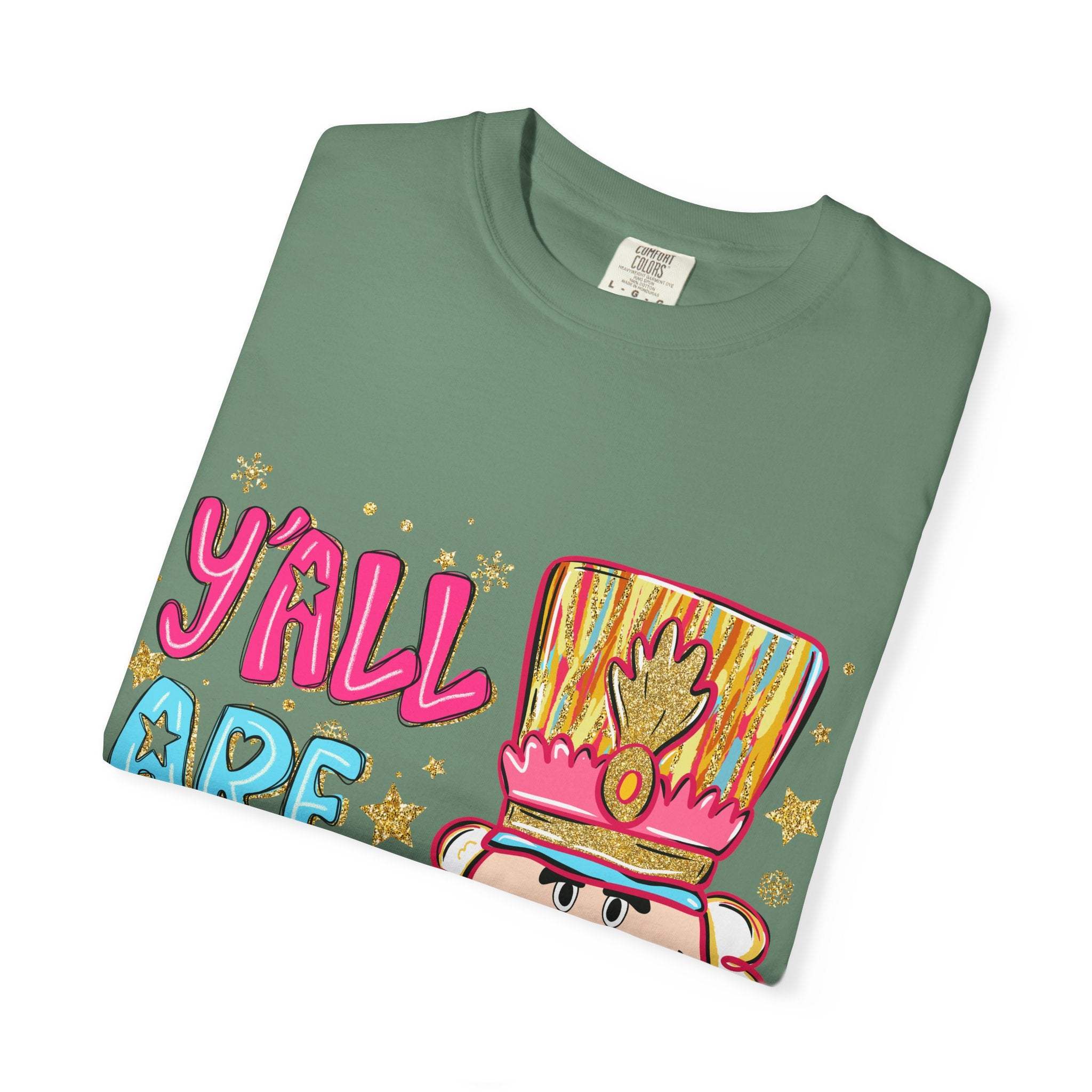 Folded green Yall Are Nuts Nutcracker holiday T-shirt with colorful festive design and nutcracker graphic