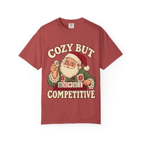 Flat lay of a Crimson red Comfort Colors T-shirt with Santa holding a mahjong tile above a tile rack and cream “Cozy But Competitive” lettering.