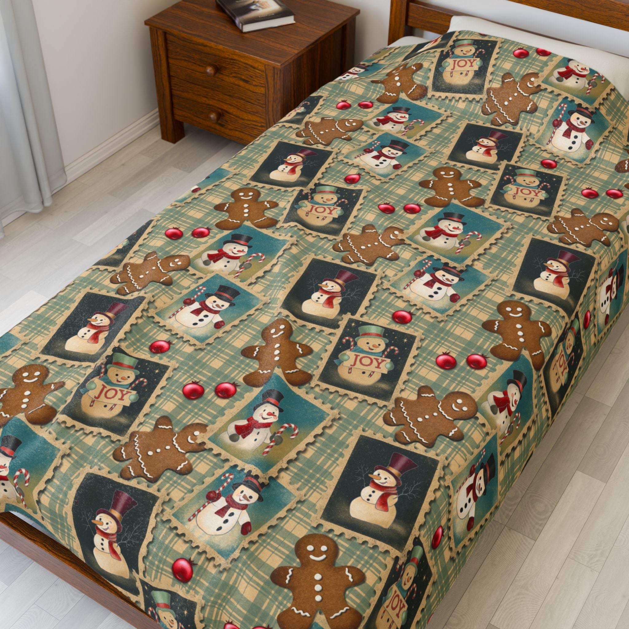 Plush blanket with retro Christmas watercolor design featuring gingerbread men and snowmen on a bed