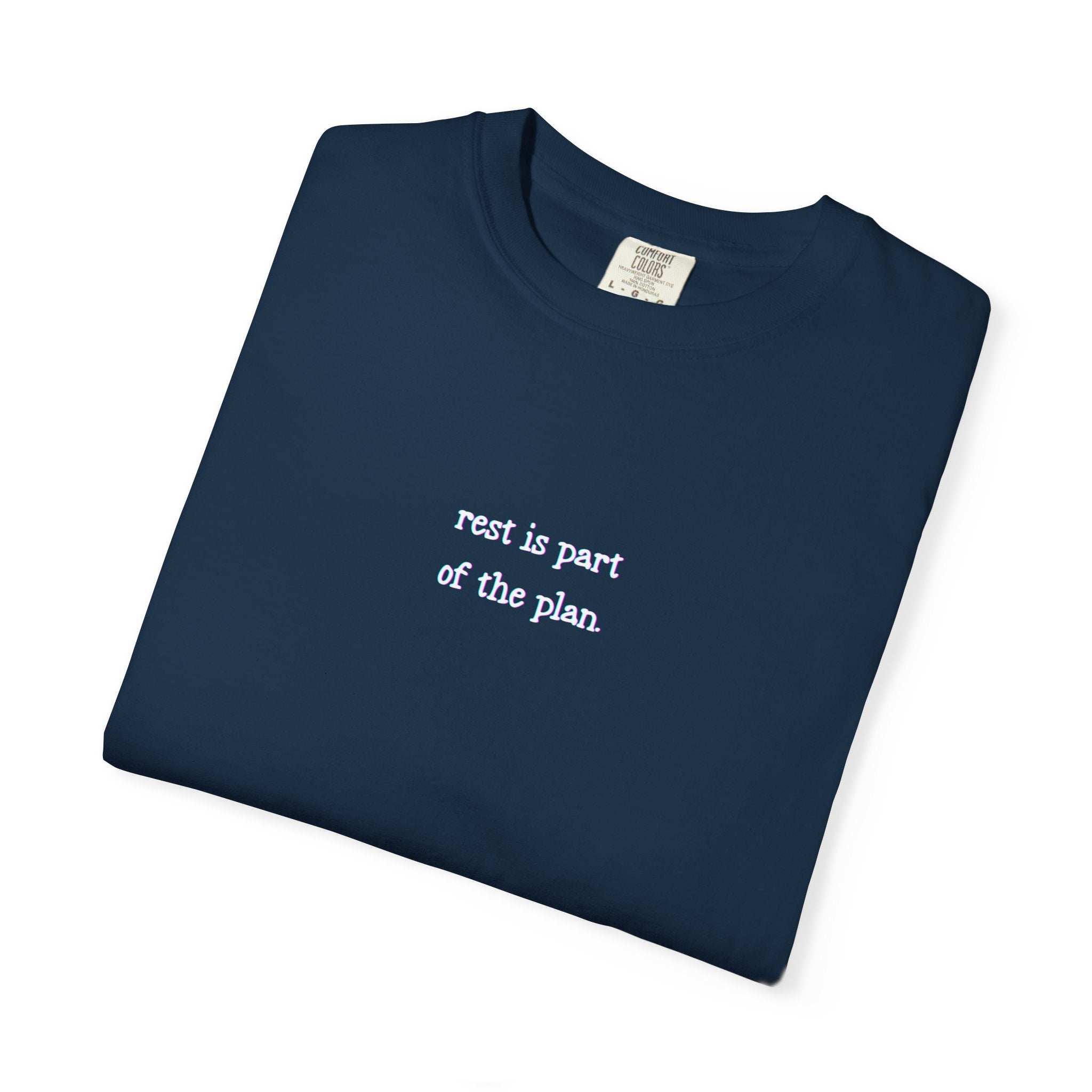 Folded navy blue t-shirt with 'rest is part of the plan' text on a white background
