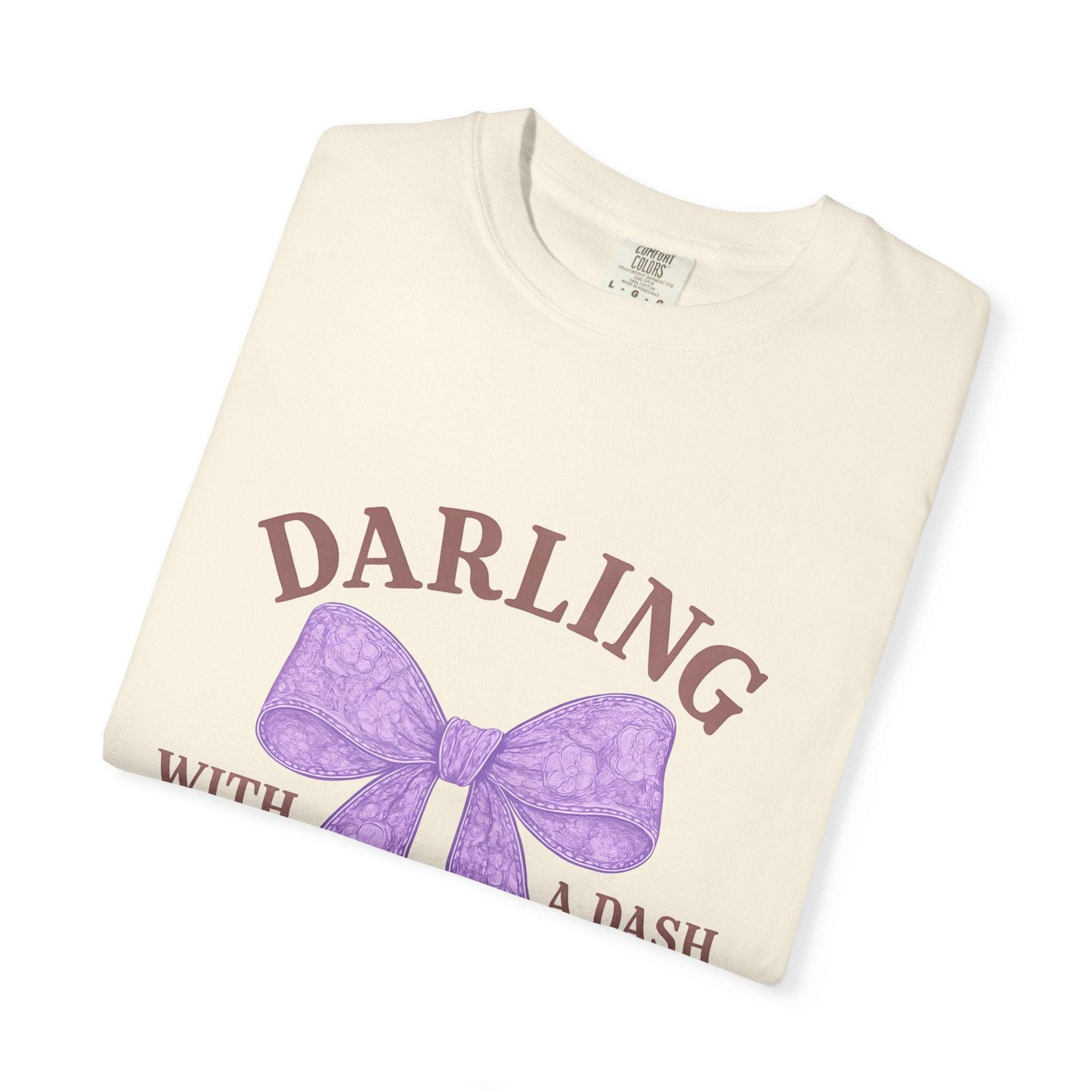 Folded cream-colored sweatshirt with purple bow and text on a white background