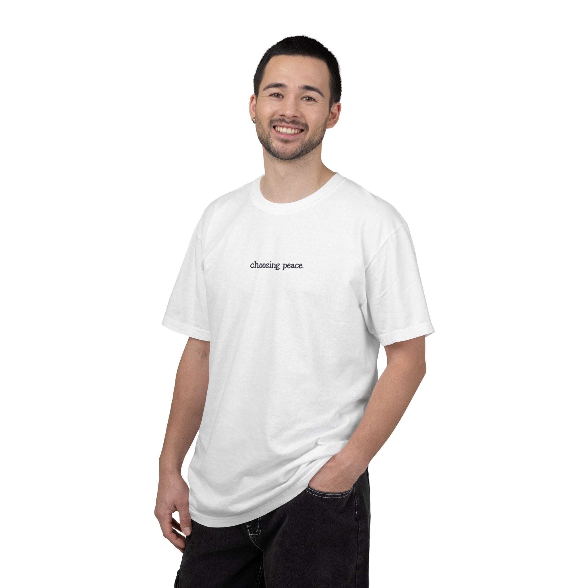 Man wearing a white t-shirt with 'chasing peace' text on a white background
