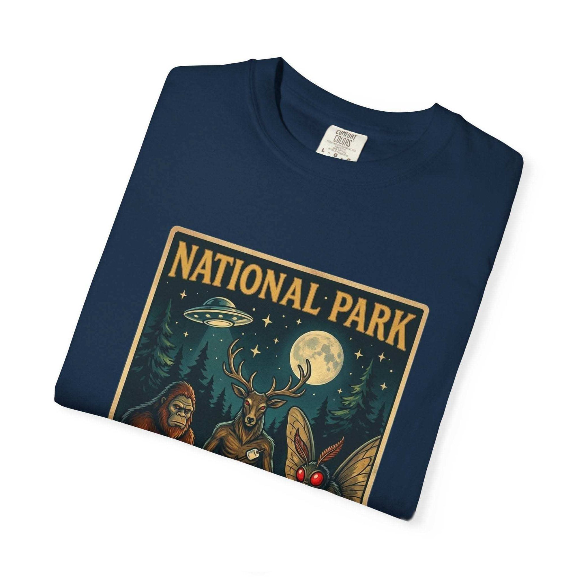 National Park After Dark t-shirt with campfire, moonlit trees, Sasquatch and Mothman night creatures design