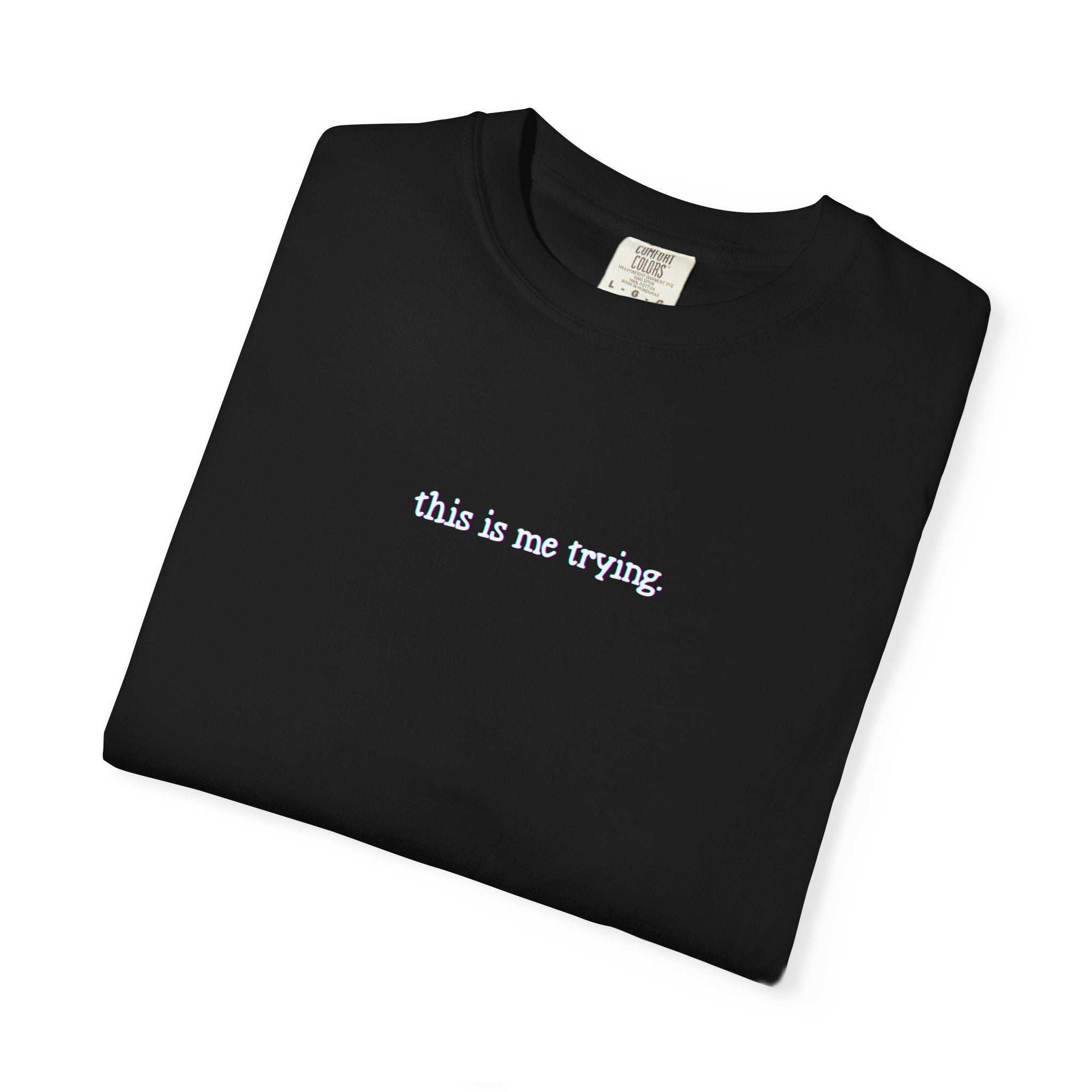 Black t-shirt with 'this is me trying' text on a white background