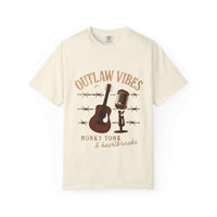 Beige t-shirt with 'Outlaw Vibes' graphic design featuring a guitar, microphone, and barbed wire on a white background.
