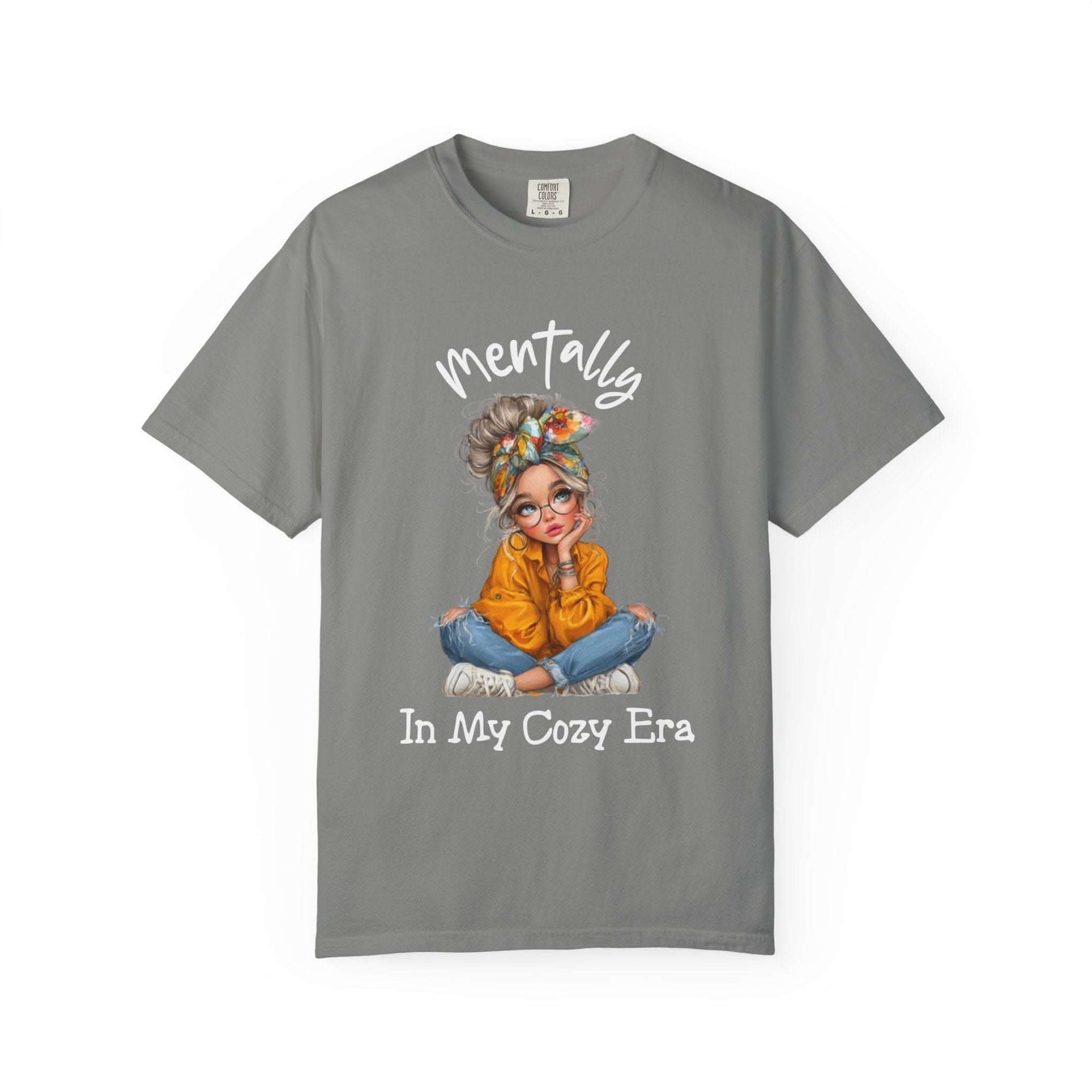 Gray Mentally in My Cozy Era T-shirt with graphic of a girl in glasses and orange sweater sitting cross-legged