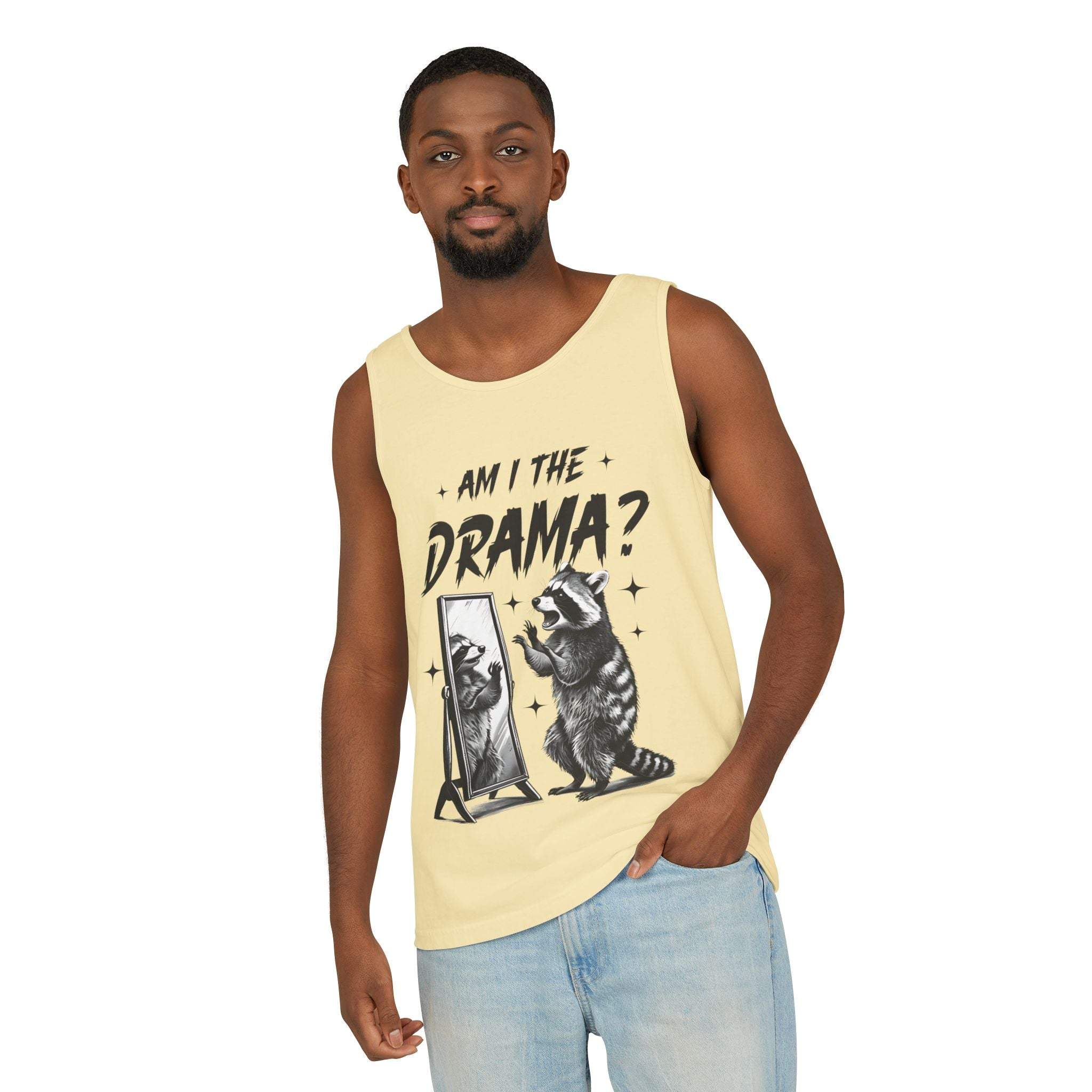 Man wearing yellow "Am I The Drama" graphic tank top with raccoon design and light blue jeans