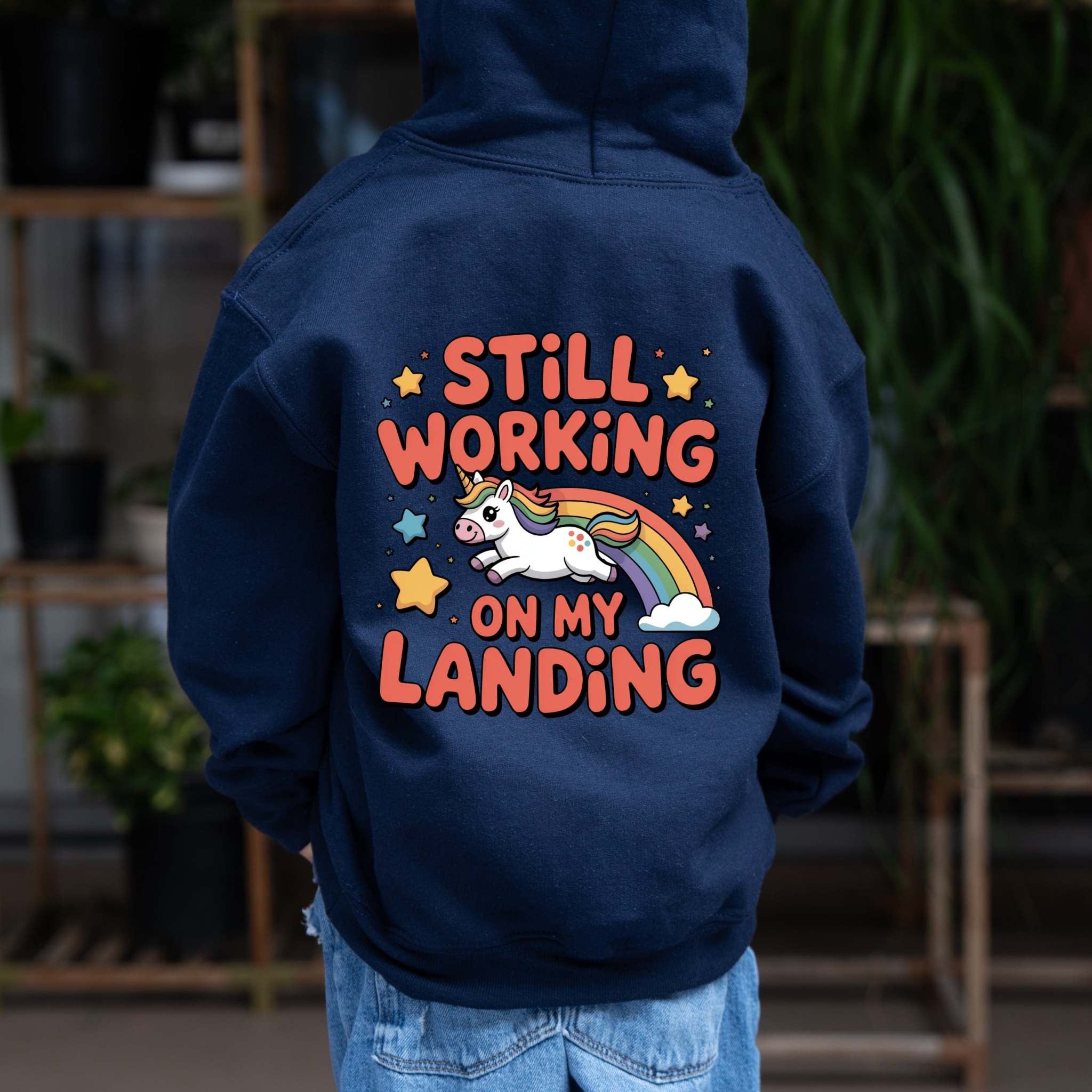 Kids hoodie with cartoon unicorn and rainbow, "Still Working On My Landing" design