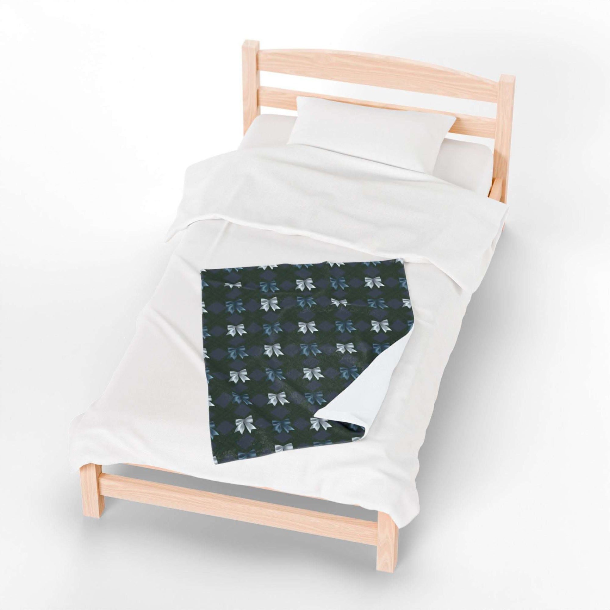 Velveteen plush blanket with winter coquette bows pattern on bed