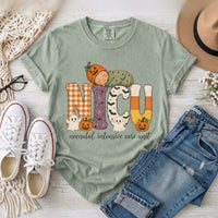 Bay green NICU nurse Halloween T-shirt with patchwork lettering, a sleeping baby in a pumpkin hat, ghosts, and jack-o’-lanterns.