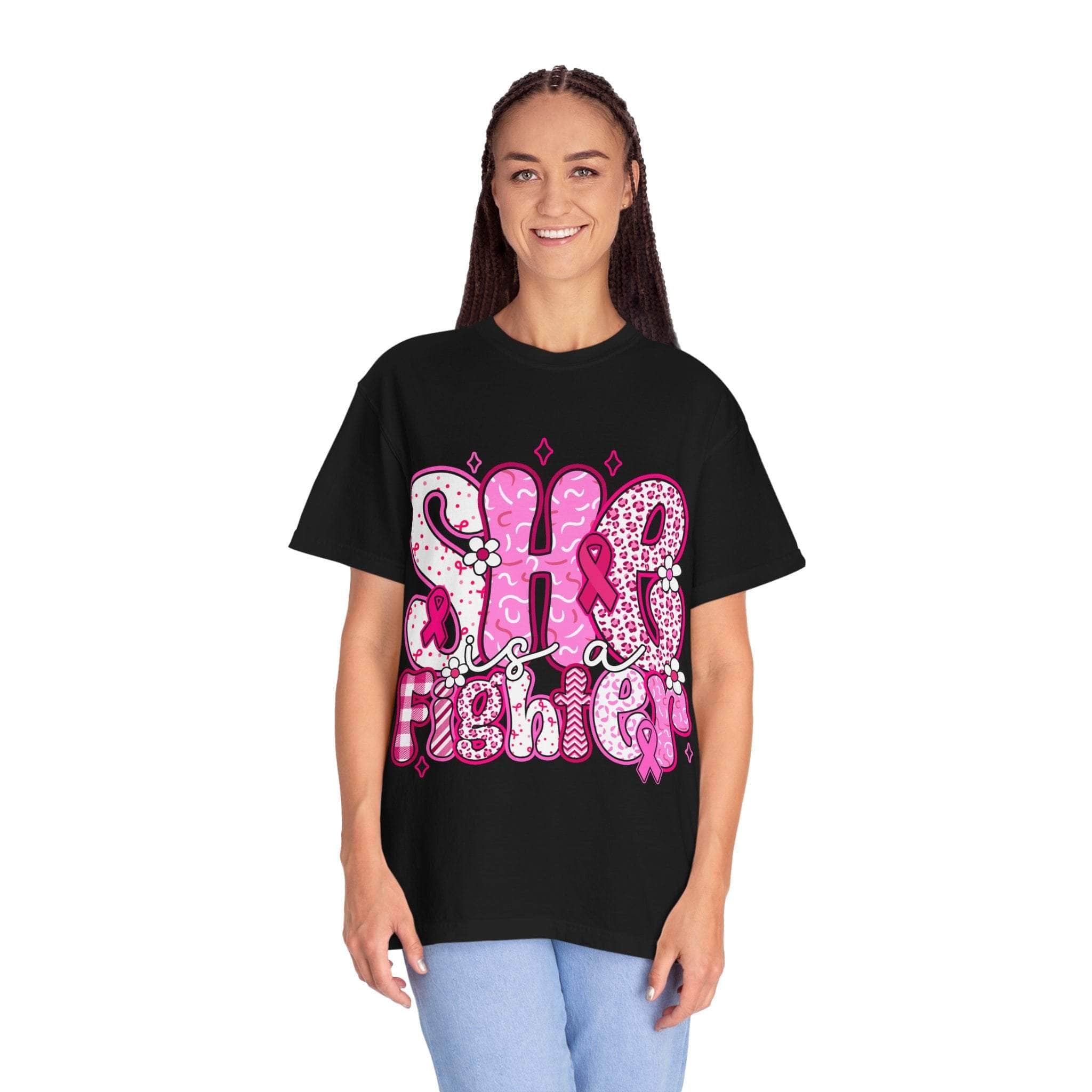Unisex black Fighter Breast Cancer T-shirt with pink "She is a Fighter" design, soft garment-dyed cotton, relaxed fit.