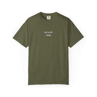 Green t-shirt with text 'soft is still strong' on a white background