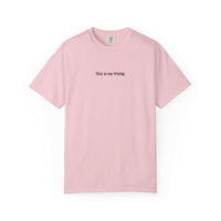Pink t-shirt with 'this is me trying' text on a white background