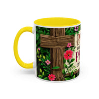 Mug with yellow handle and floral design featuring a wooden cross and flowers on a white background