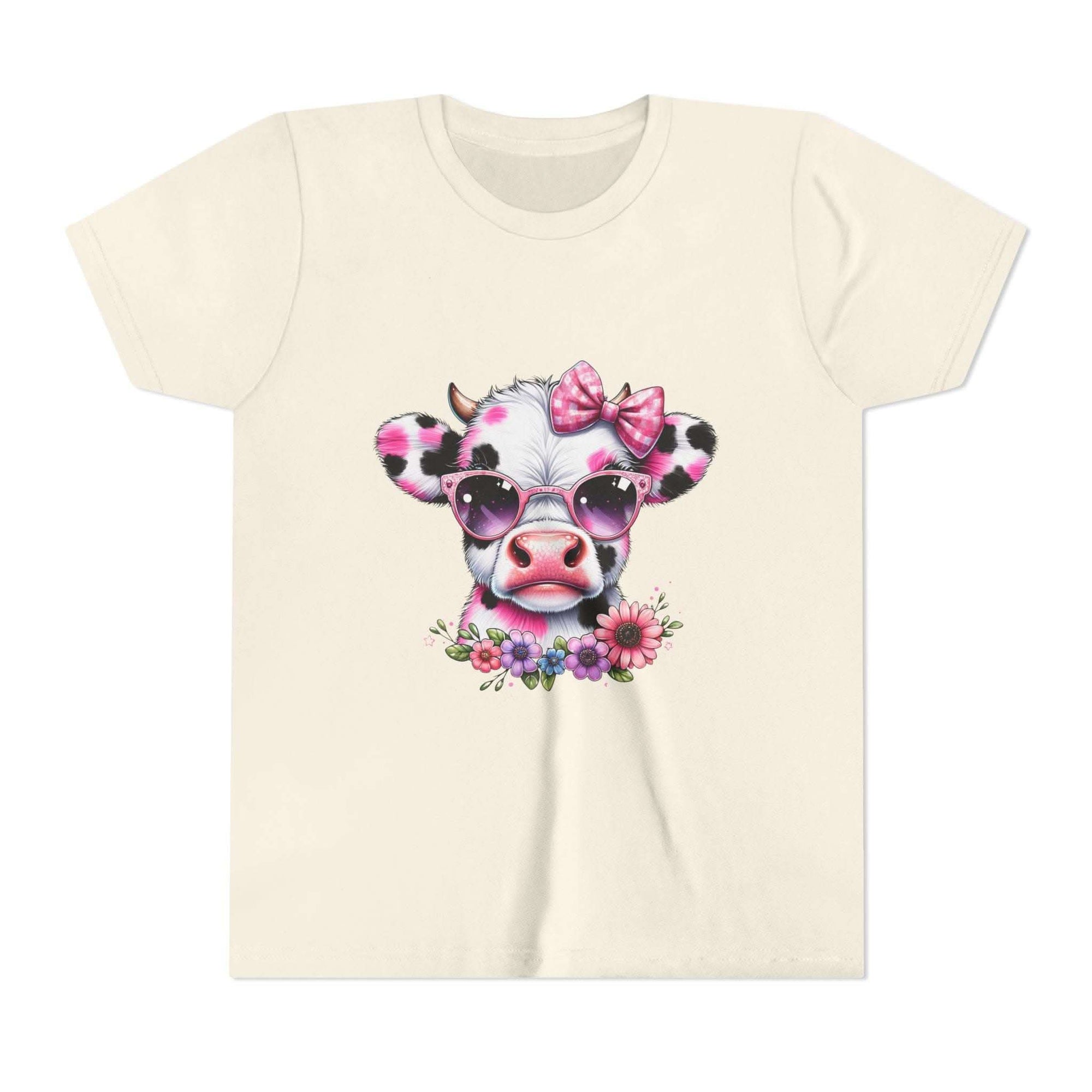 Beige t-shirt with a cow design wearing sunglasses and a bow, on a white background