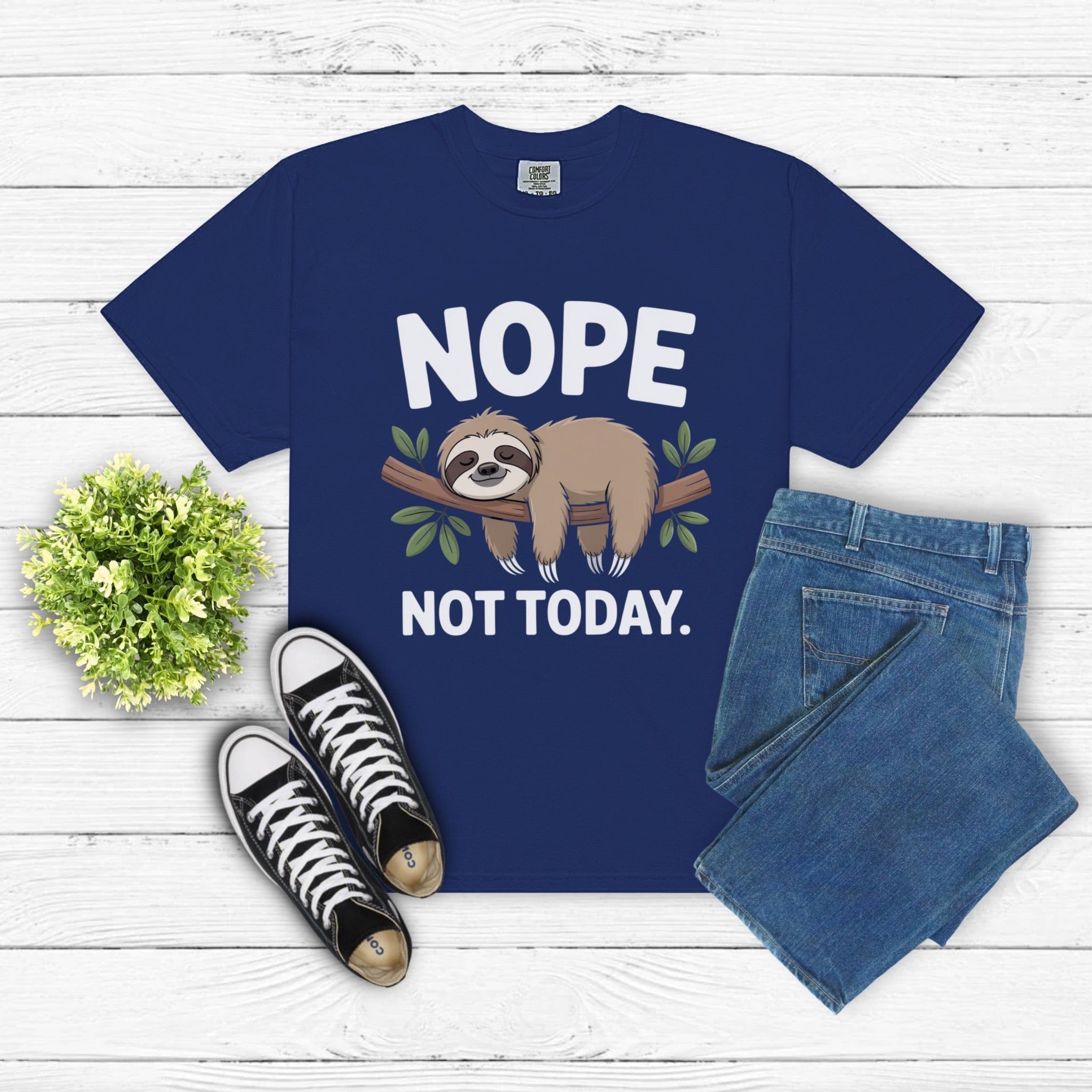 Nope Not Today Sloth T-shirt with sloth graphic and text on blue cotton fabric, paired with jeans and sneakers on white wooden background