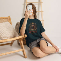 Surreal glowing-eyed Mothman cryptid wrapped in blanket holding coffee mug on cozy cryptid tee
