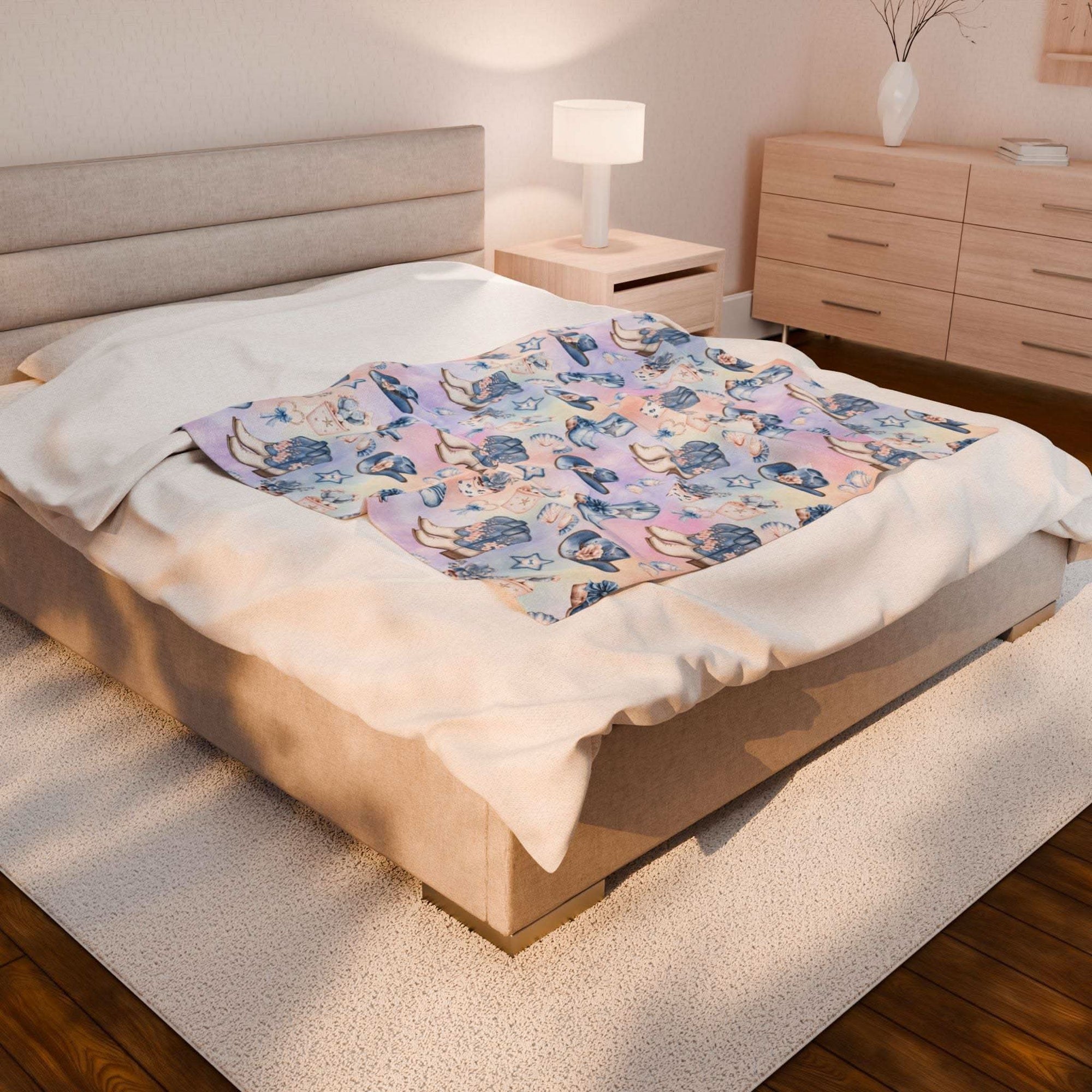 Plush blanket with Coastal Cowgirl design on bed in modern bedroom setting