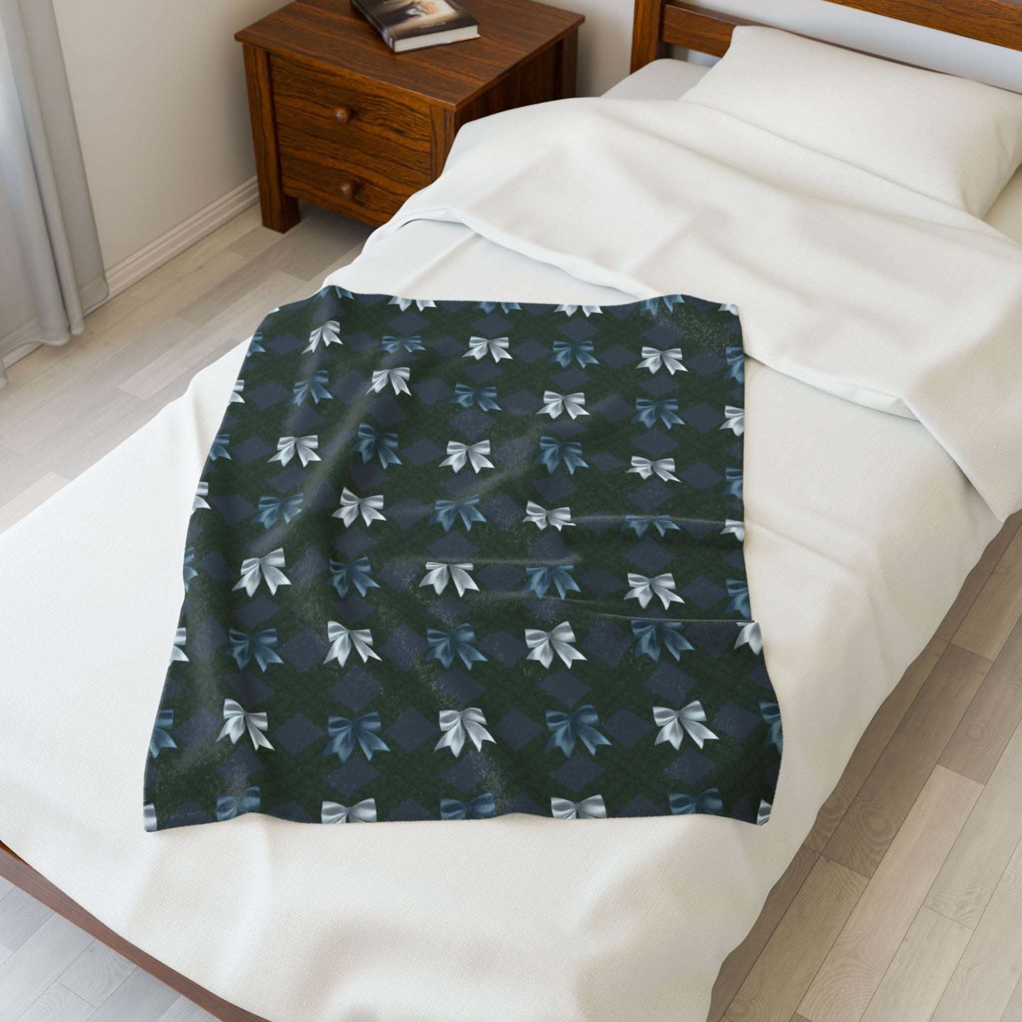 Velveteen plush blanket with winter coquette bows design on bed in cozy bedroom setting