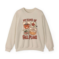 A beige crewneck sweatshirt featuring a graphic print with the text 'MY KIND OF FALL PLANS' and four autumn-themed illustrations of a coffee mug, a maple leaf, a sandwich, and a cinnamon roll.