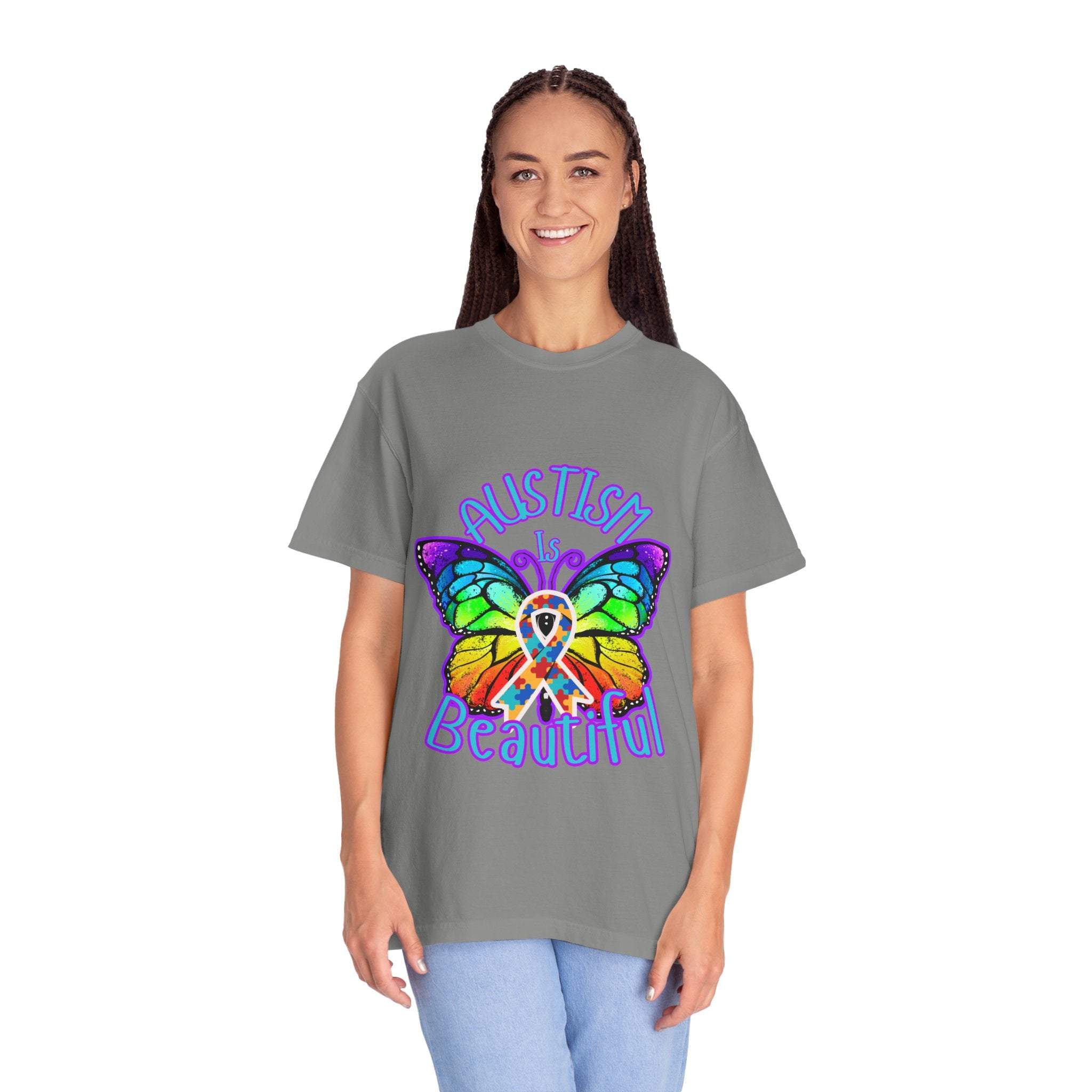 Woman wearing grey Autism is Beautiful T-shirt with colorful butterfly and awareness ribbon design promoting autism acceptance and support