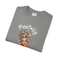 Folded gray Mentally in My Cozy Era T-shirt with hand-lettered text and illustration of a woman with glasses and headscarf