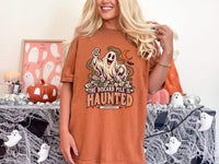 Model wearing yam orange Comfort Colors 1717 Halloween mahjong T-shirt with a ghost holding a tile and “The Discard Pile Is Haunted (Obviously)” lettering.