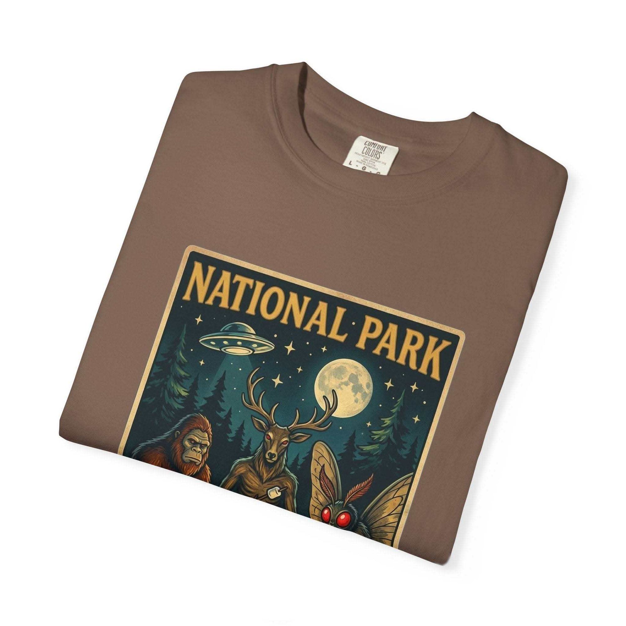 National Park After Dark t-shirt with campfire, moonlit trees, Sasquatch and Mothman night creatures design