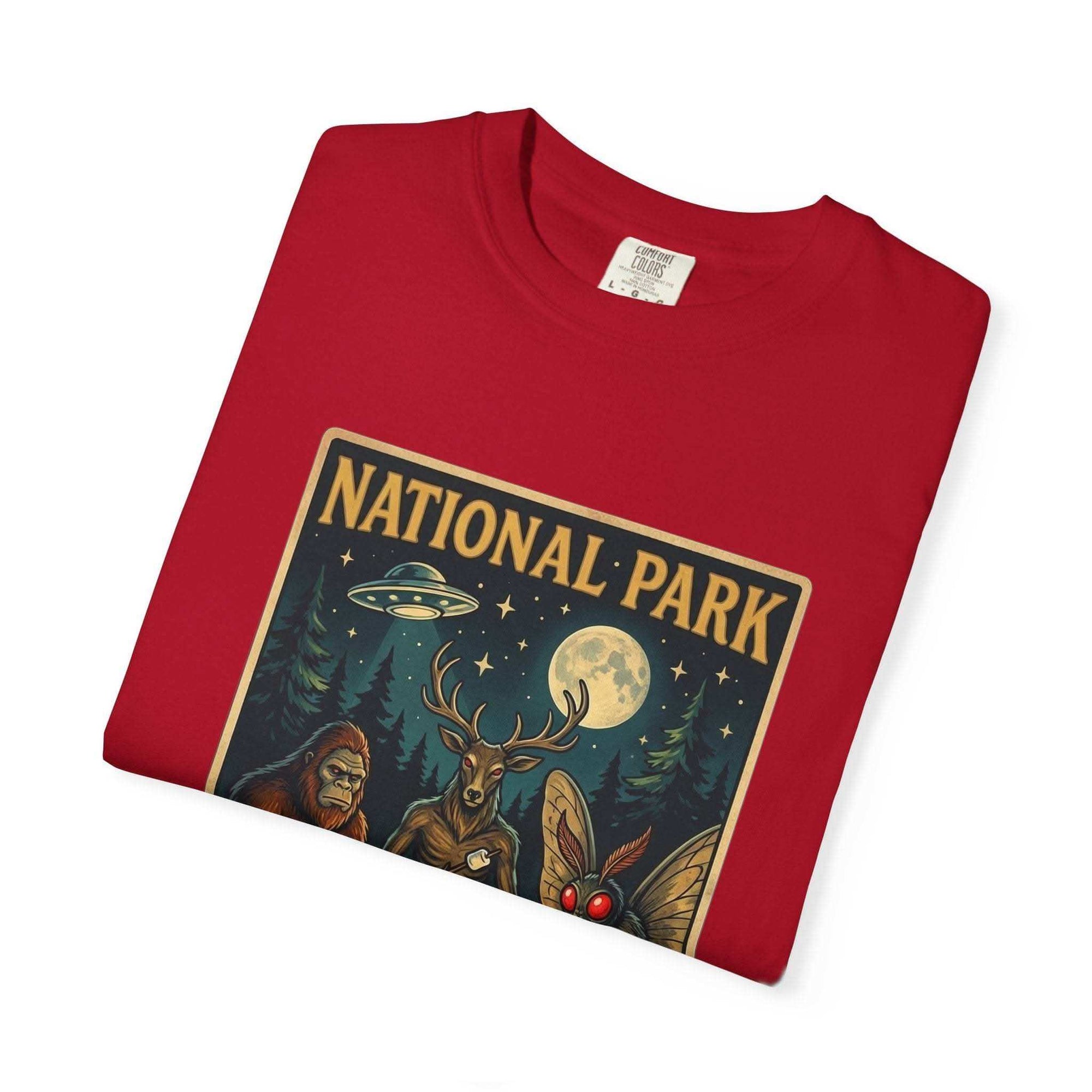 National Park After Dark t-shirt featuring campfire, Sasquatch, Mothman, and night creatures in a vintage woodland design